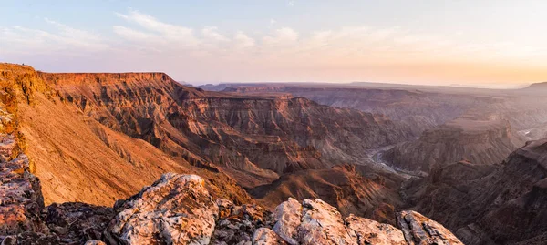 Fish River Canyon, scenic travel destination in Southern Namibia. Last sunlight on the mountain ridges. Wide angle view from above. — Stock Photo, Image