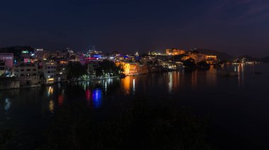Geceleri parlayan cityscape Udaipur. Görkemli Sarayı yansıtan ışıklar üzerinde PICHOLA Lake, seyahat hedef, Rajasthan Hindistan
