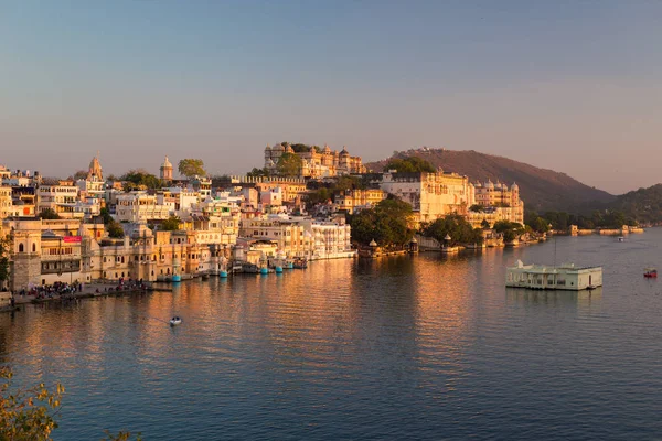 Udaipur városkép a naplemente. A fenséges város palota Pichola tó, úti cél, Rajasthan, India — Stock Fotó