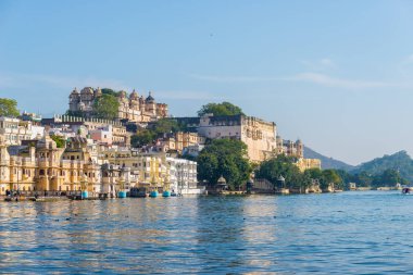 Gün batımında Udaipur cityscape. Göl PICHOLA, seyahat hedef, Rajasthan Hindistan görkemli şehir sarayının