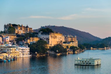 Gün batımında Udaipur cityscape. Göl PICHOLA, seyahat hedef, Rajasthan Hindistan görkemli şehir sarayının