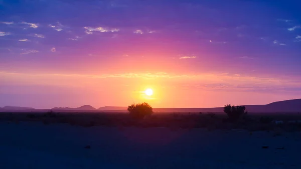 Auringonnousu Namibin autiomaan yllä, automatka upeassa Namib Naukluftin kansallispuistossa, matkakohde Namibiassa, Afrikassa. Aamuvalo, sumu ja sumu . — kuvapankkivalokuva