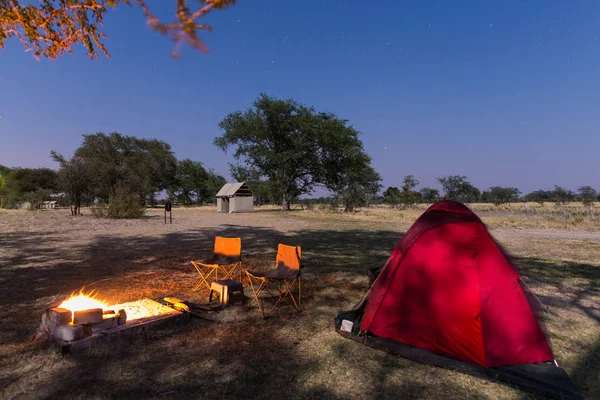 Yıldızlı gökyüzü gece kamp sitesi. Milli Parkı, Afrika macera. Kamp ateşi ve çadır arka planda yazdırma. — Stok fotoğraf