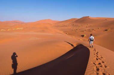Turist Sossusvlei, Namib Çölü, Namib Naukluft Milli Parkı, Namibya doğal tepeleri üzerinde yürüme. Öğleden sonra ışık. Macera ve keşif Afrika.