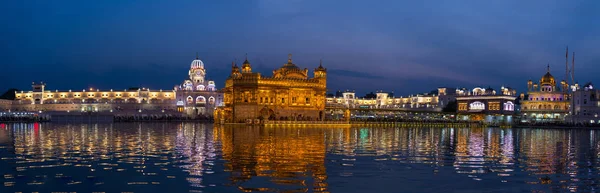 De gouden tempel in Amritsar, Punjab, India, de heiligste pictogram en aanbidding plaats van de Sikh religie. Verlicht in de nacht, tot uiting op meer. — Stockfoto