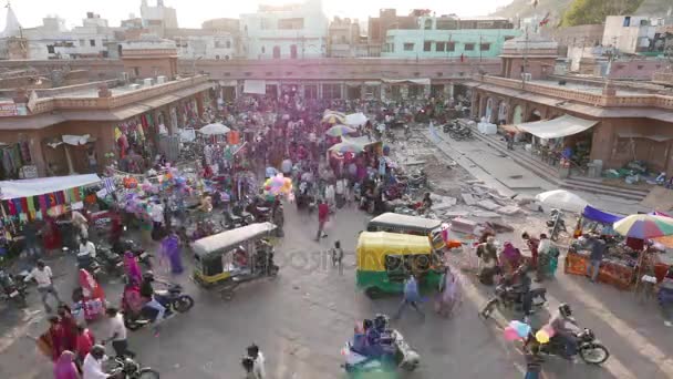 Jodhpur, India - luty 2017: ludzie, pojazdy, zwierzęta i towary w zatłoczonym rynku przy placu wieży zegarowej w Jodhpur, India. Upływ czasu od góry. — Wideo stockowe