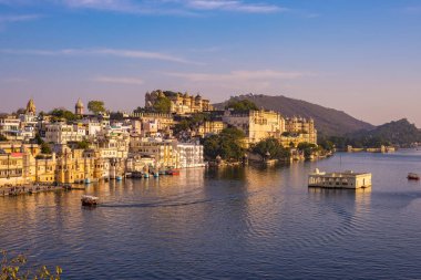 Göl günbatımı ışığı yansıtan PICHOLA ünlü şehir sarayının. Udaipur, seyahat hedef ve turistik Rajasthan, Hindistan