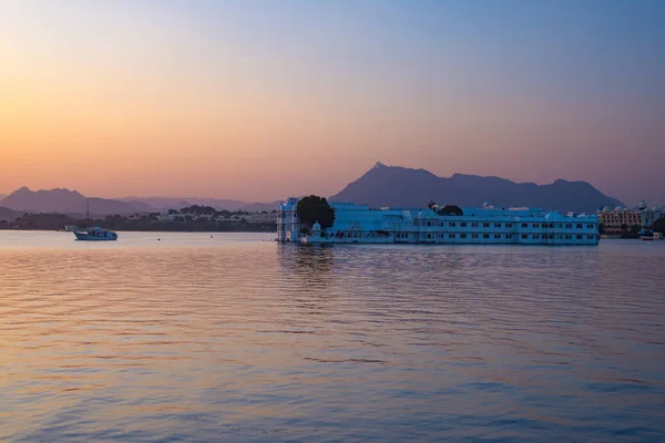 Slavný bílý palác plovoucí na jezeře Pichola při západu slunce. Udaipur, cíl cesty a turistickou atrakcí v Rajasthan, Indie — Stock fotografie