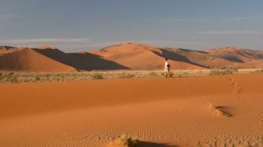 Turist Sossusvlei, Namib Çölü, Namib Naukluft Milli Parkı, Namibya doğal tepeleri üzerinde yürüme. Öğleden sonra ışık. Macera ve keşif Afrika.