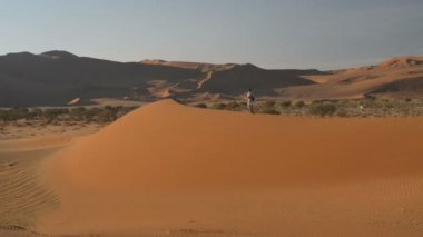 Turist Sossusvlei, Namib Çölü, Namib Naukluft Milli Parkı, Namibya doğal tepeleri üzerinde yürüme. Öğleden sonra ışık. Macera ve keşif Afrika.