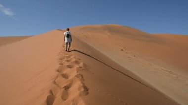 Turist Sossusvlei, Namib Çölü, Namib Naukluft Milli Parkı, Namibya doğal tepeleri üzerinde yürüme. Öğleden sonra ışık. Macera ve keşif Afrika.