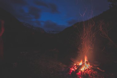 Kamp ateşi içine uzak Karaçam ve çam ağacı orman yüksek irtifa Peyzaj ve dramatik gökyüzü gece karanlığında yakma. İtalyan Fransız Alpleri'nde yaz Maceraları.