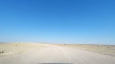 Yoldan çakıl Namib Çölü'nde üzerinde ay yatay olarak sürüş, Namibya, Afrika hedef, seyahat. Araba bağlı kameradan görüntülemek.