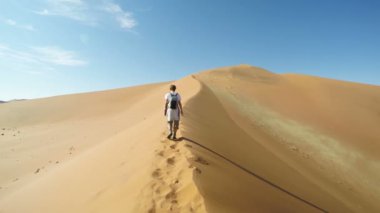 Turist Sossusvlei, Namib Çölü, Namib Naukluft Milli Parkı, Namibya doğal tepeleri üzerinde yürüme. Öğleden sonra ışık. Macera ve keşif Afrika. Ağır çekim.