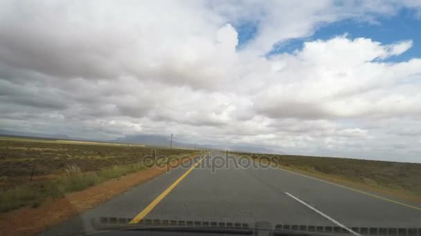 Conduciendo por la carretera de dos carriles que cruza la floreciente Namaqualand en Sudáfrica. Vista desde la cámara montada en coche . — Vídeo de stock