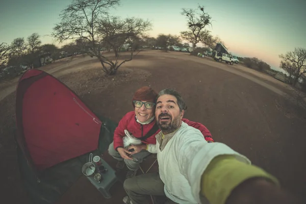 Alacakaranlıkta kamp sitedeki yetişkin çift alarak selfie. Macera National Park, Güney Afrika. Tonlu görüntü. — Stok fotoğraf