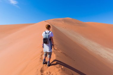 Turist Sossusvlei, Namib Çölü, Namib Naukluft Milli Parkı, Namibya doğal tepeleri üzerinde yürüme. Macera ve keşif Afrika.
