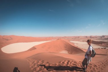 Turist Sossusvlei, Namib Çölü, Namib Naukluft Milli Parkı, Namibya doğal tepeleri üzerinde yürüme. Öğleden sonra ışık. Macera ve keşif Afrika.