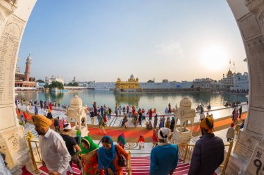 Turistler ve en kutsal kutsal kişilerin resmi ve ibadet, Amritsar, Pencap, Hindistan karmaşık altın tapınak içinde yürüyüş tapan Sih din yerleştirin. Bulanık hareket, uzun pozlama.