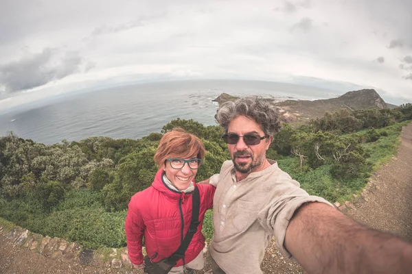 Casal tirando selfie em Cape Point, Table Mountain National Park, destino de viagem cênica na África do Sul. Fisheye vista de cima . — Fotografia de Stock