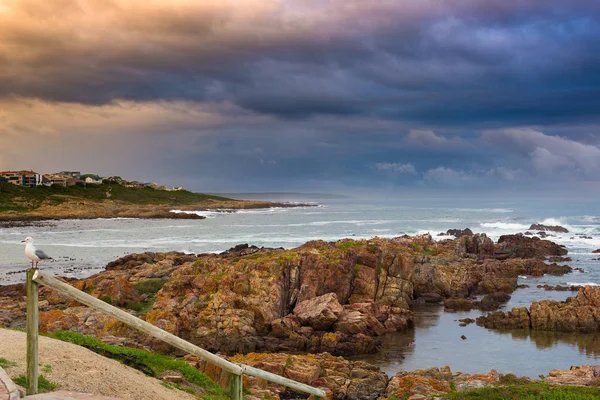 Linha costeira rochosa no oceano em De Kelders, África do Sul, famosa pela observação de baleias. Estação de inverno, céu nublado e dramático . — Fotografia de Stock