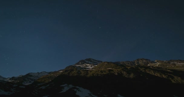 La aparente rotación del cielo estrellado y la luna llena sobre los majestuosos Alpes italianos, bajo la brillante luz de la luna. Tiempo de caducidad — Vídeos de Stock