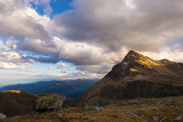 Última luz solar cálida en el valle alpino con picos de montaña brillantes y nubes escénicas. Alpes franceses italianos, destino de viaje de verano . — Foto de Stock