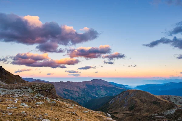 Ultima calda luce solare sulla vallata alpina con vette scintillanti e nuvole panoramiche. Alpi francesi italiane, destinazione turistica estiva . — Foto Stock