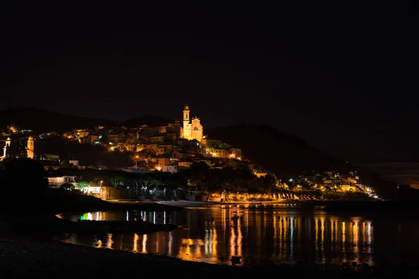 The historical town of Cervo glowing in the night under moonlight and starry sky on the coastline of Ligurian Riviera, famous travel destination in Italy. — Stock Photo, Image