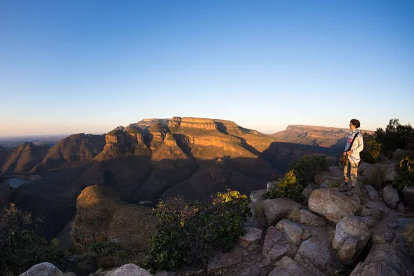Blyde River Canyon, destino de viaje en Sudáfrica. Turista mirando el panorama. Última luz del sol en las cordilleras. Ojo de pez distorsionó la vista desde arriba . — Foto de Stock