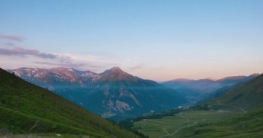 Karlı dağ sırtlar ve tepeler üzerine yaz, Torino eyaletinin, İtalya Alpleri'nde. Şafak zaman atlamalı solma gündoğumu. Yamaçları Dağı'na giden yol geçiş sarma geçmek.
