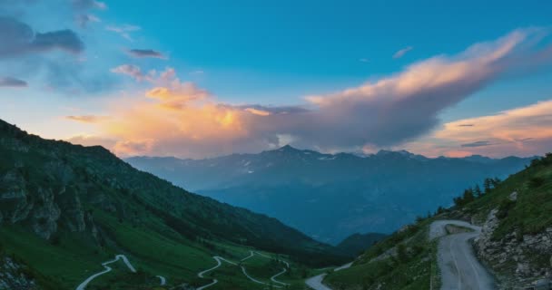 Χιονισμένες κορυφογραμμές και κορυφές με κινούμενα σύννεφα πάνω από τις Άλπεις το καλοκαίρι, επαρχία του Τορίνο, Ιταλία. Ώρα λήξη ξεθώριασμα από την ηλιακή ακτινοβολία στο σούρουπο. — Αρχείο Βίντεο