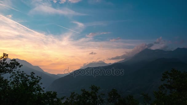 Schneebedeckte Bergkämme und Gipfel mit beweglichen Wolken über den Alpen im Sommer, Provinz Torino, Italien. Zeitraffer vom Sonnenlicht bis zur Dämmerung. — Stockvideo