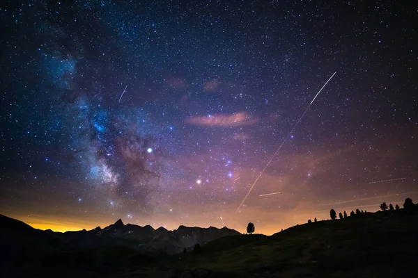 El colorido núcleo luminoso de la Vía Láctea y el cielo estrellado capturado a gran altura en verano en los Alpes italianos, provincia de Torino. Tráfico de aviones en el cielo . —  Fotos de Stock