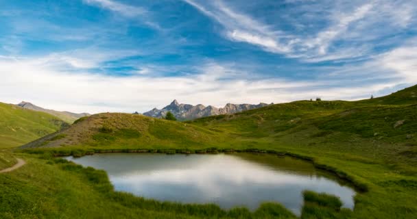 Горные вершины и альпийское озеро с движущимися облаками над Альпами летом, наблюдаемые от Италии до национального парка Кейрас, Франция. Временной промежуток на закате — стоковое видео