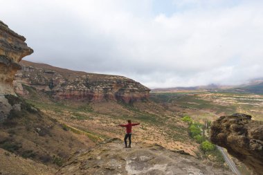 Turist ile ayakta kol uzanmış ve görkemli Golden Gate Highlands Milli Parkı'nda, panoramik manzaraya bakarak seyahat hedef Güney Afrika. Macera ve pe seyahat kavramı