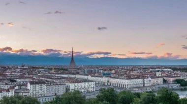 Mole Antonelliana binalar üzerinde yükselen ile Torino (Turin, İtalya) manzarası. Alacakaranlıkta için günbatımı solma, şehir ışıkları yakmaya Timelapse. Alpler üzerinden hareket bulutlar