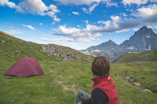 Majestuosa vista de brillantes picos de montaña al atardecer en lo alto de los Alpes. Vista trasera de una persona mirando a la vista, enfoque en el fondo . — Foto de Stock