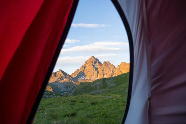 Olhando para a paisagem da montanha ao nascer do sol a partir do interior da tenda de acampamento. Aventura viajando nos majestosos Alpes Europeus, atividades ao ar livre de verão . — Fotografia de Stock