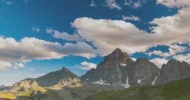 Karlı dağ sırtlar ve yaz, Torino eyaletinin, İtalya Alpleri'nde üzerinde yüksek bulutlar. Zaman atlamalı gün batımında. Statik sürüm.