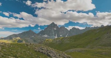 Karlı dağ sırtlar ve yaz, Torino eyaletinin, İtalya Alpleri'nde üzerinde yüksek bulutlar. Zaman atlamalı gün batımında. Statik sürüm.