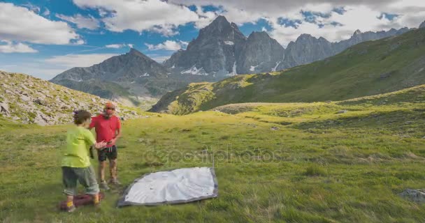 Deux personnes installant une tente de camping sur les montagnes, le temps presse. Aventures sur les Alpes, majestueux pic en arrière-plan (M. Viso, 3841 m, Province de Turin, Italie ). — Video