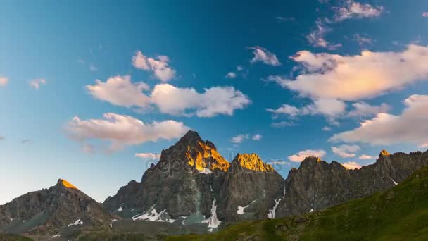 Cumes de montanhas cobertas de neve e picos com nuvens em movimento sobre os Alpes no verão, Província de Torino, Itália. Tempo limite ao pôr-do-sol . — Vídeo de Stock