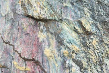 Close up of colorful rock surface, natural background, pattern and texture. Metamorphic white quartzite folded and fractured together with red coarse sandstone, due to the power of geologic crustal mo clipart