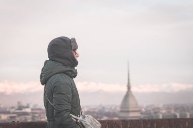 Panoramik manzaralı bir balkon yukarıdaki Torino (Turin, İtalya) bakarak turist. Kış saati, karlı Alps içinde belgili tanımlık geçmiş. Seçici odak, vintage tarzı, görüntü tonda.