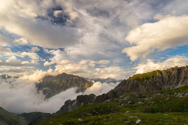 Última luz solar quente no vale alpino com picos de montanha brilhantes e nuvens cênicas. Alpes franceses italianos, destino de viagem de verão . — Fotografia de Stock
