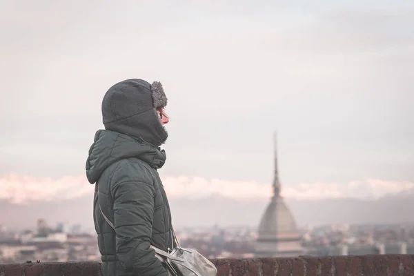Tourist looking at panoramic view of Torino (Turin, Italy) from balcony above. Winter time, snowcapped Alps in the background. Selective focus, vintage style, toned image. — Stock Photo, Image