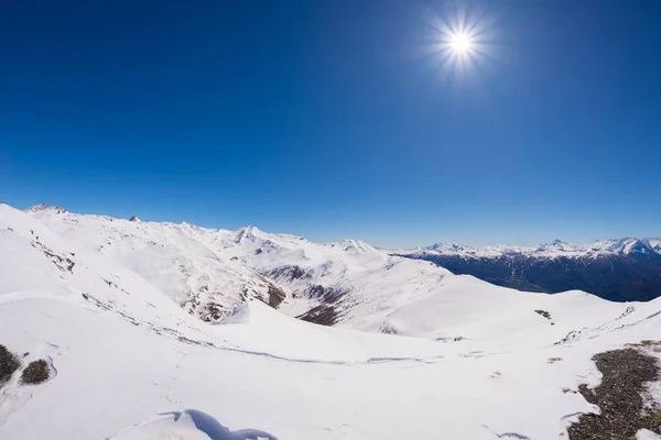 Szeroki kąt widzenia ośrodek narciarski w oddali z eleganckim szczyty wynikające z łuku alpejskim w sezonie zimowym. Prowincja Torino na granicy Francja Włochy. — Zdjęcie stockowe