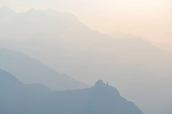 Μπλε τονισμένο μακρινή οροσειρά των Άλπεων με Αβαείο Άγιος Michel προφίλ στο κάτω μέρος. Επαρχία του Τορίνο, Πιεμόντε, Italy. Θέα τηλεφακό, απαλό φως στο ηλιοβασίλεμα. — Φωτογραφία Αρχείου