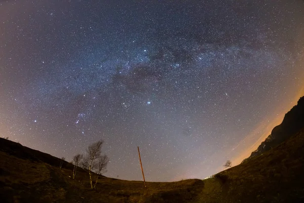 El cielo estrellado y la Vía Láctea capturados en los Alpes por lente de ojo de pez con distorsión escénica y vista de 180 grados. Andrómeda, Las Pléyades, Orión y Sirio claramente visibles. Bajo ruido digital . — Foto de Stock